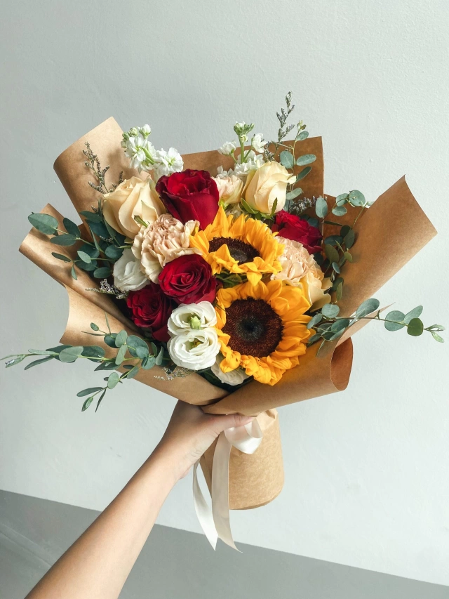 Ramo de rosas, flores surtidas y girasoles